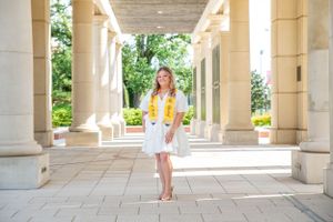 A senior posing on a college campus.