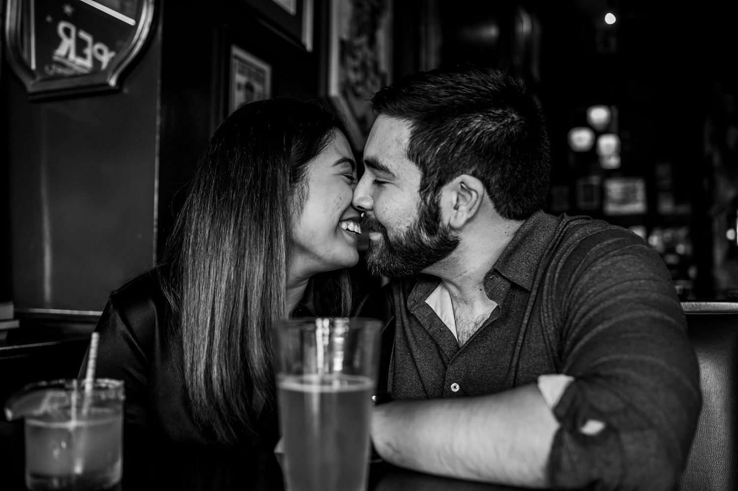 Intimate bar scene with drinks and warm lighting creating romantic atmosphere.