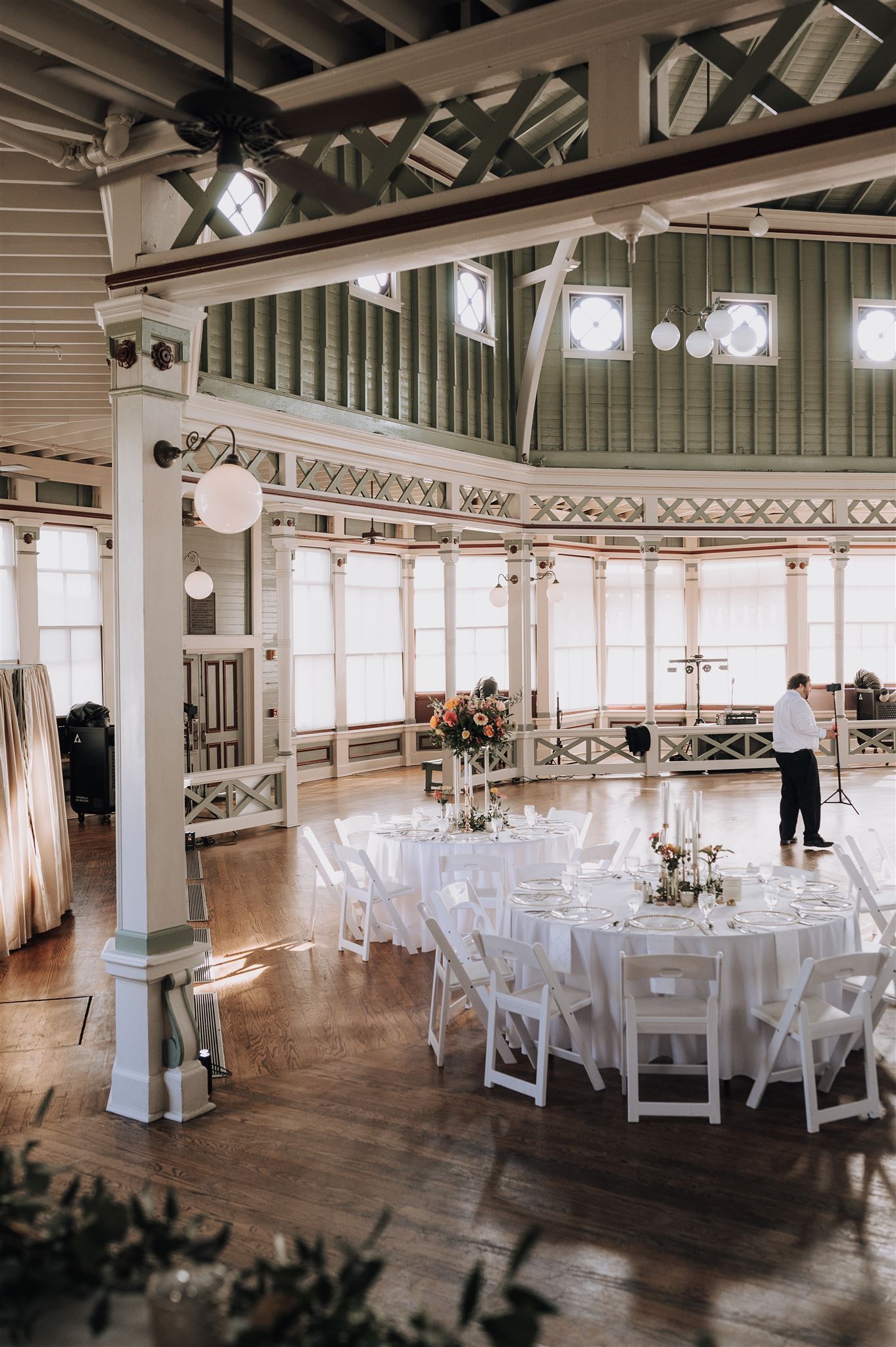 Elegant reception venue with high ceilings, white tables, and vintage architectural details.