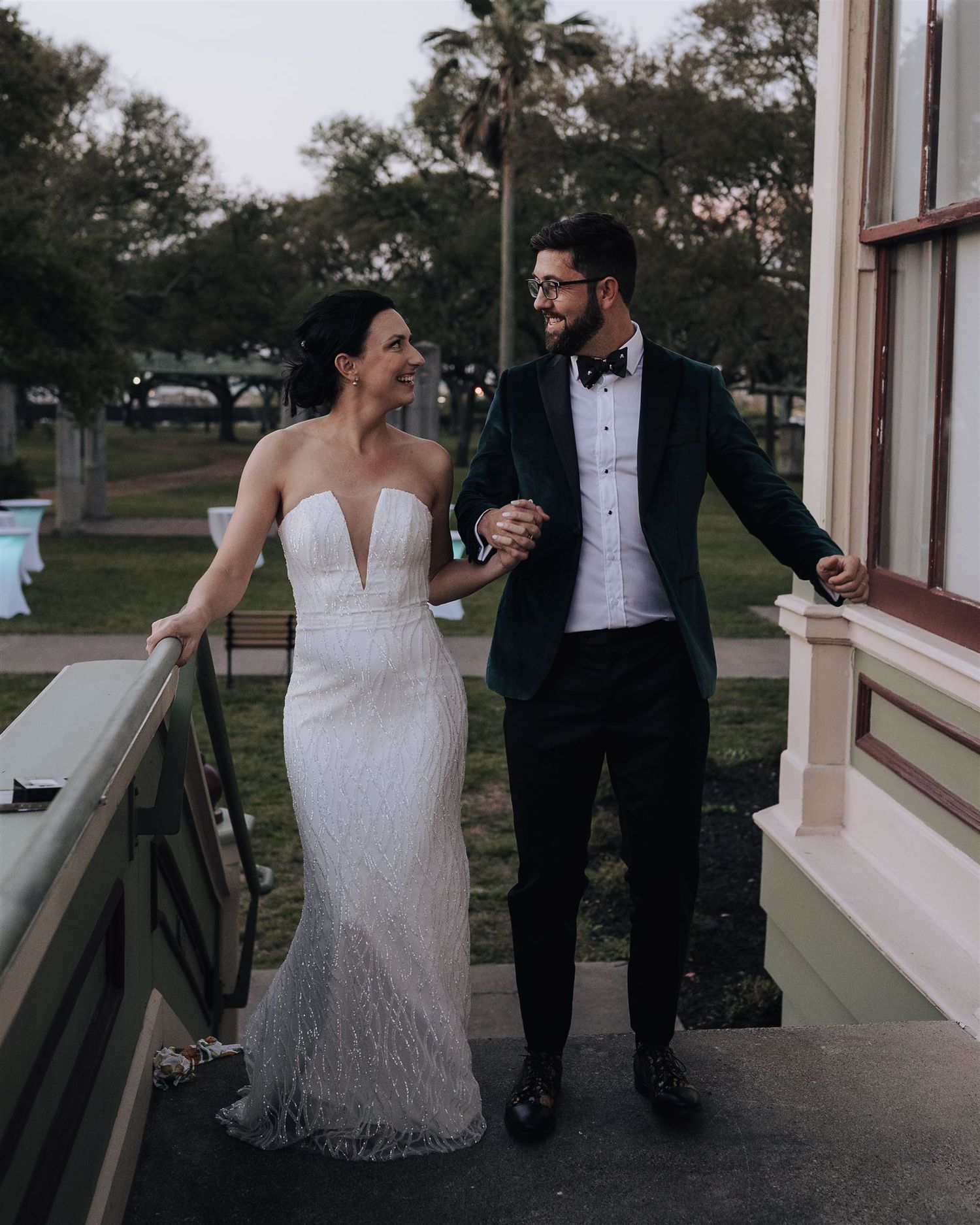 Couple sharing joyful moment while walking on vintage building porch.