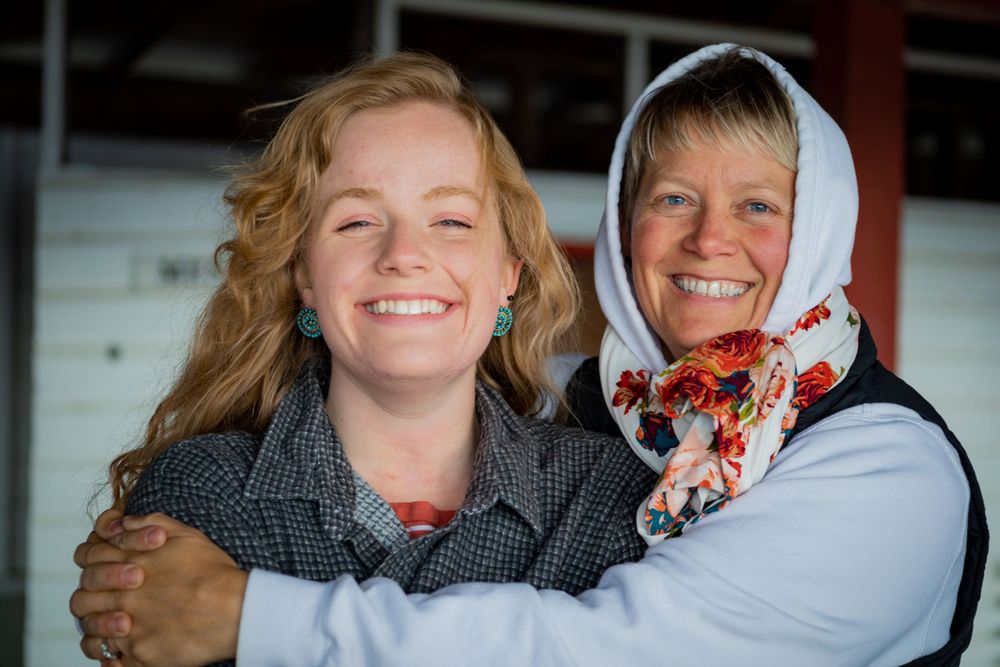 Two people wearing head scarves share a joyful moment together.