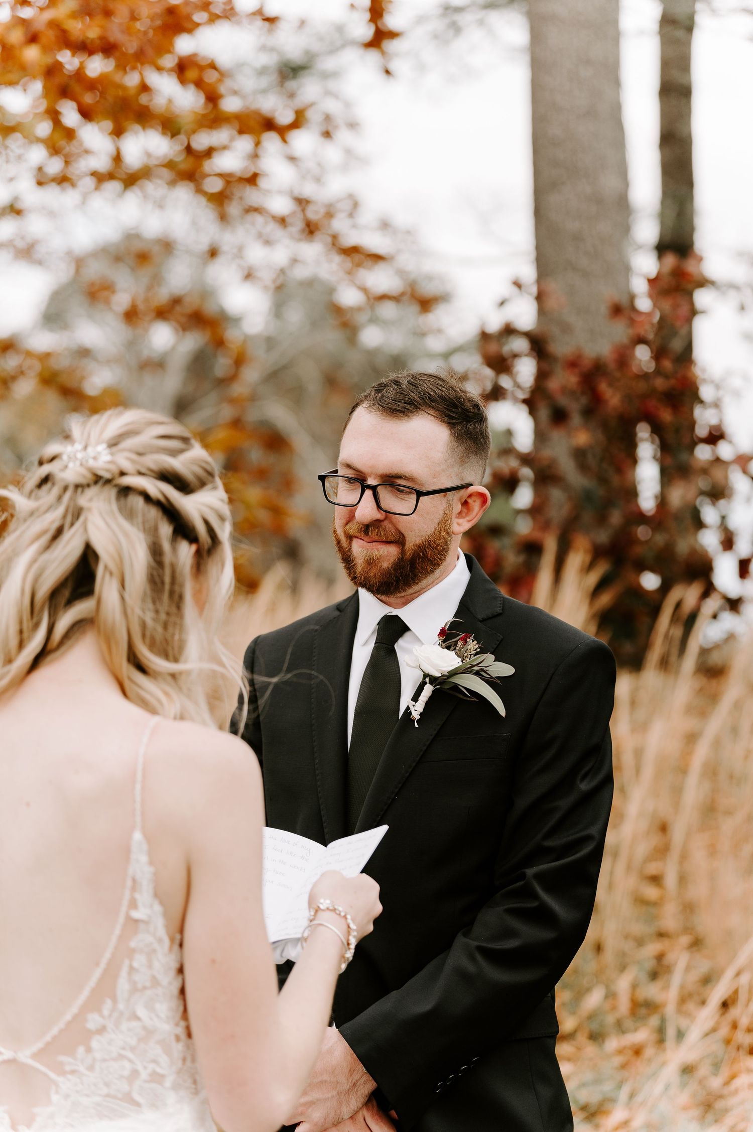 A couple exchanges emotional vows during their outdoor autumn wedding ceremony.