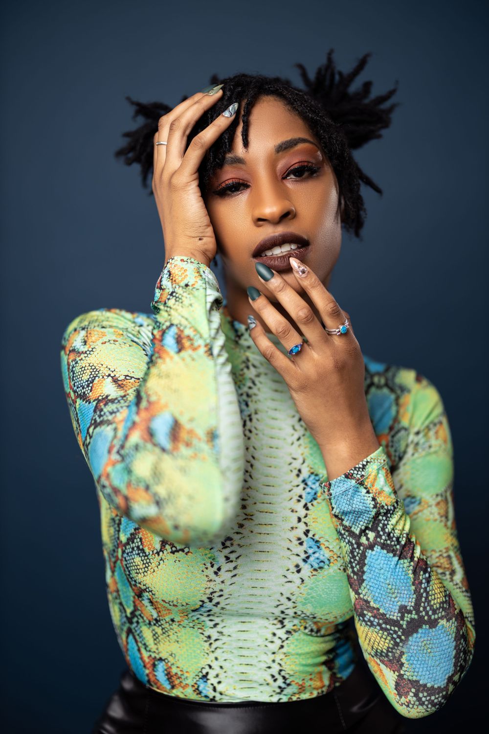 Artistic portrait showcasing colorful snakeskin print fashion and dramatic makeup.