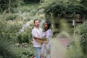 A couple enjoying a romantic moment in a serene garden setting.
