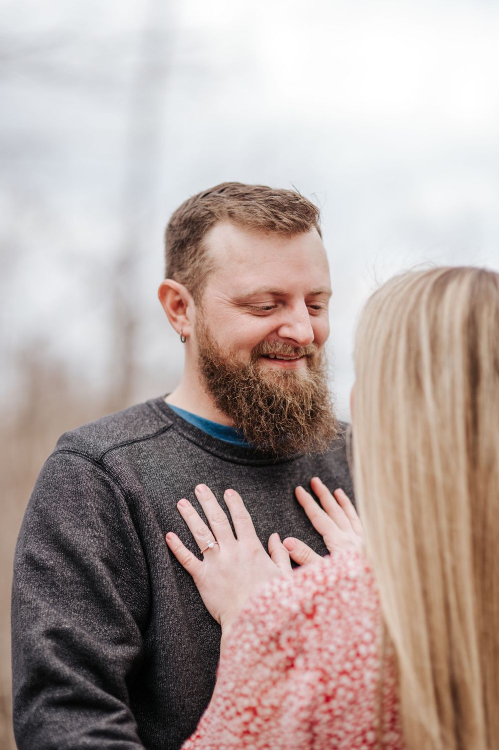 A close-up moment of joy between two people, one wearing a cozy grey sweater.