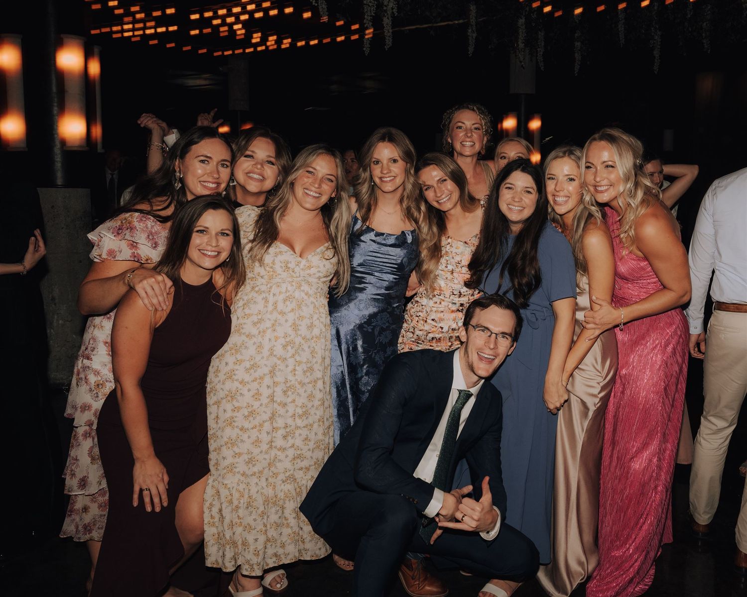 Group photo of wedding guests in formal attire gathered for a celebratory moment.