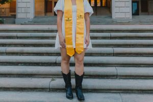 A University of Texas Senior posses in cowboy boots during her senior photoshoot with Pamela Clark