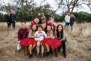 8 grandkids pose together while their parent and grandparents watch during their family session with Pamela Clark