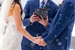 Bride and Groom holding hands during snowy ceremony in Olympic Peninsula, WA during an elopement