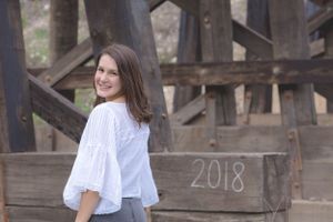 A high school senior poses under railroad bridge during a senior photoshoot with Pamela Clark in Brushy Creek