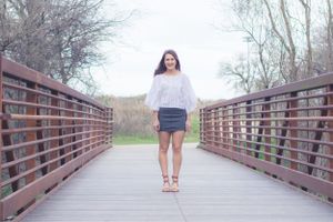 A high school senior poses on a bridge along the brushy creek trail during a session with Pamela Clark