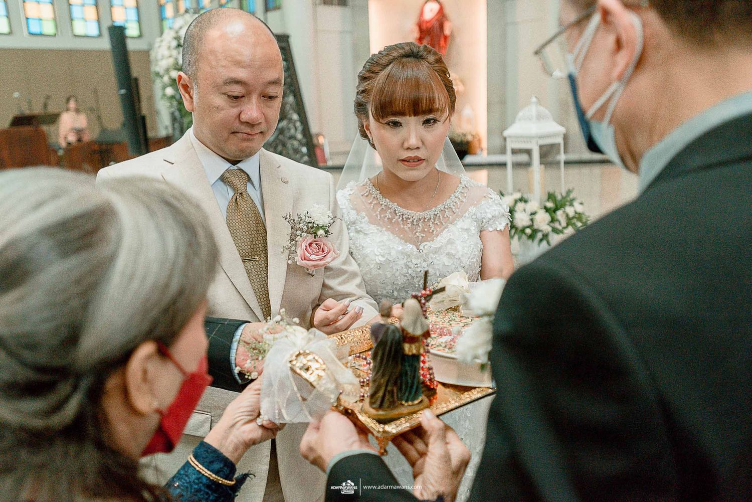 Wedding ritual taking place with attendees gathered around during church ceremony.