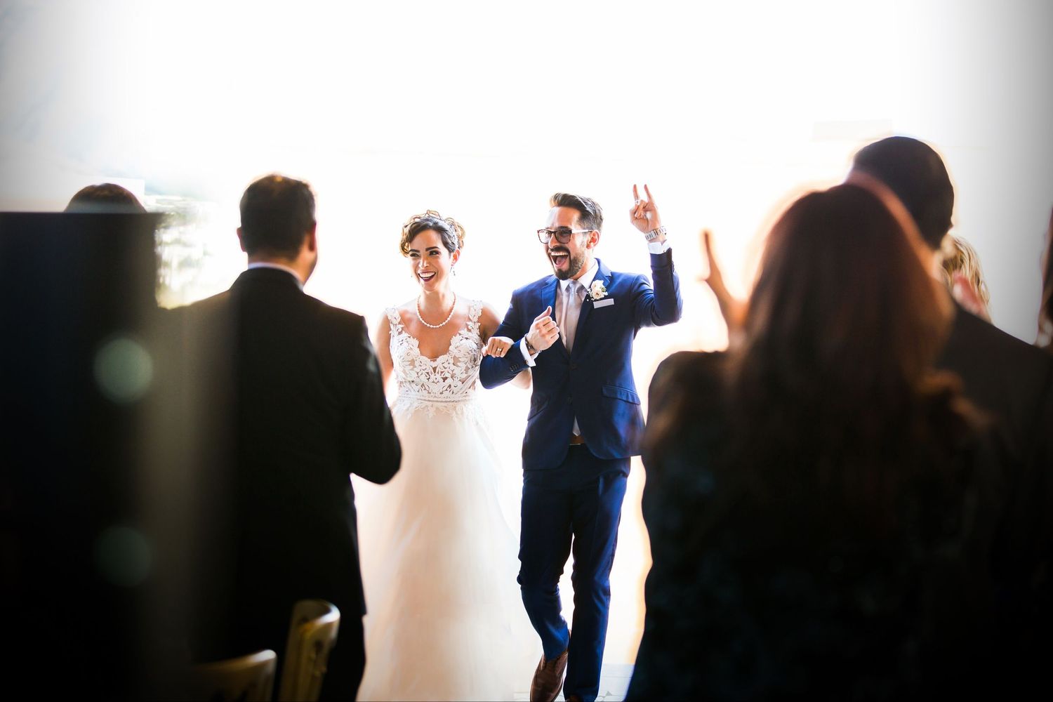 A joyous wedding ceremony moment captured in soft focus with guests in attendance.