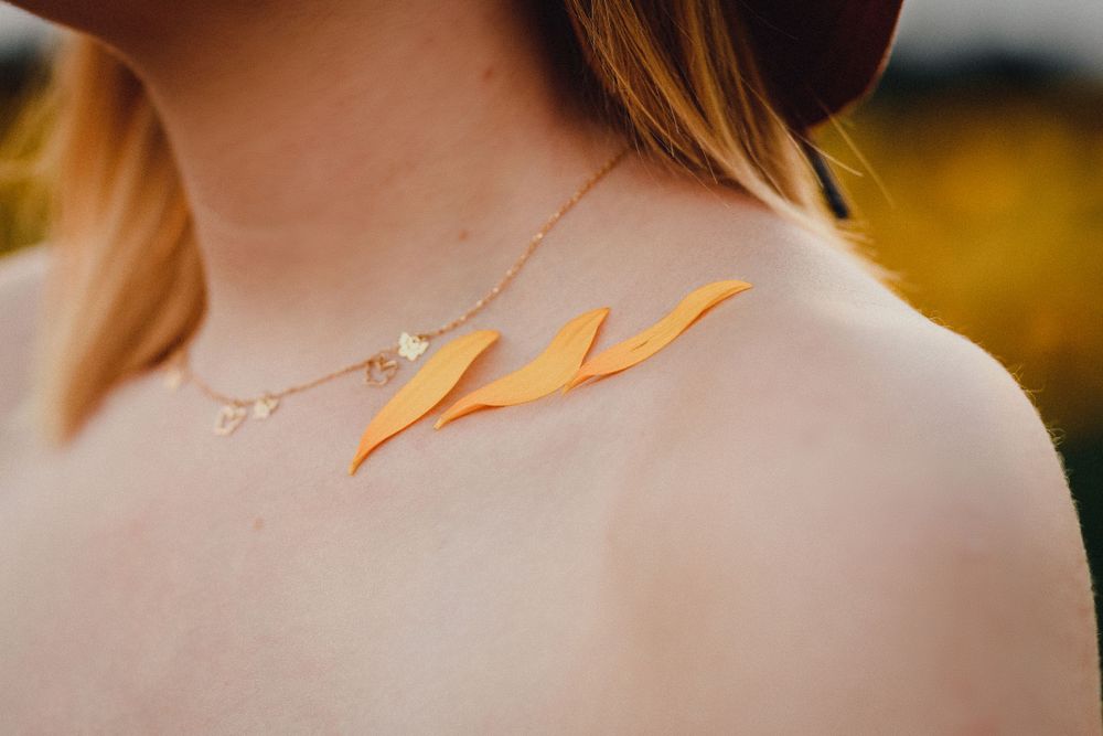 Close-up detail shot of a delicate gold necklace against skin.