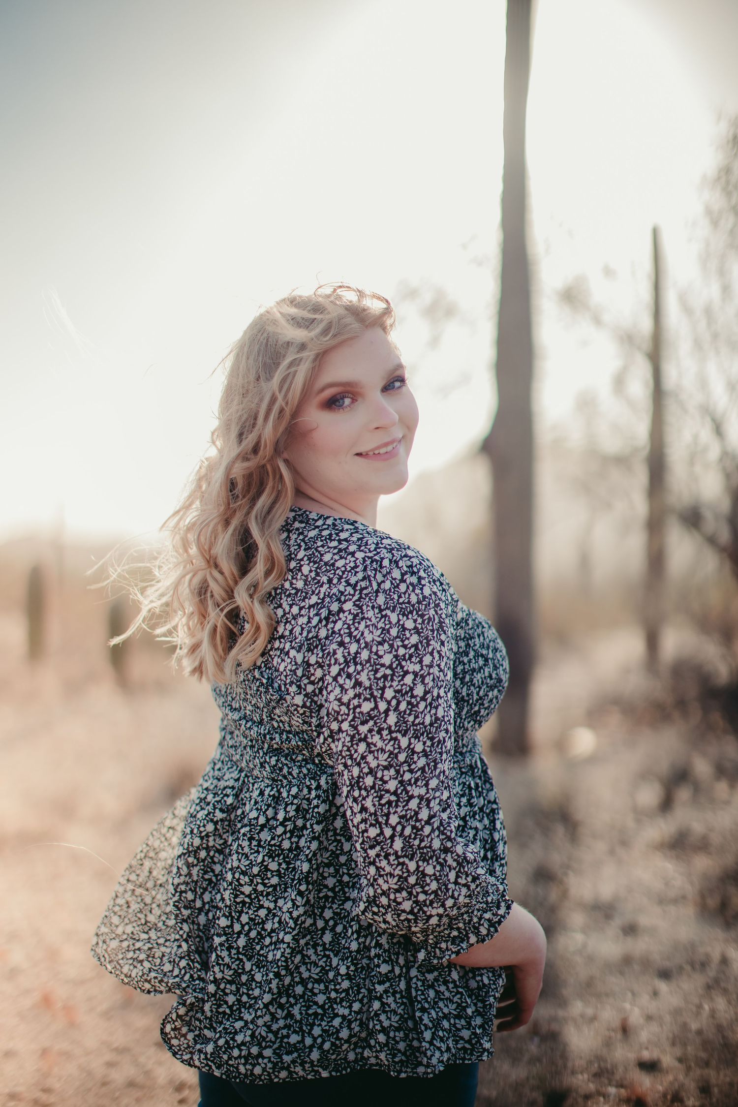 Outdoor portrait in floral dress with soft desert lighting.