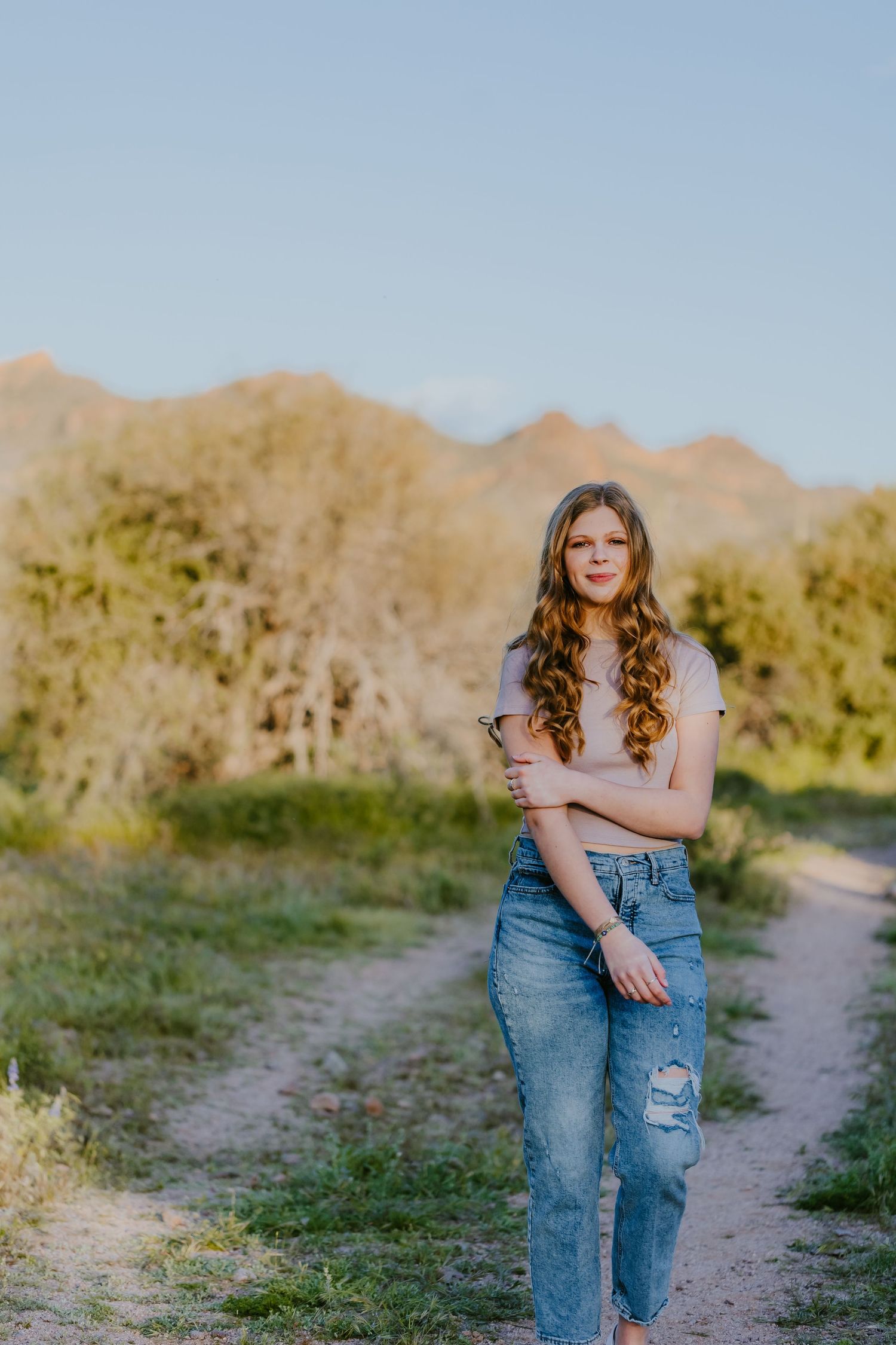 Casual portrait session on desert trail with mountains in background.