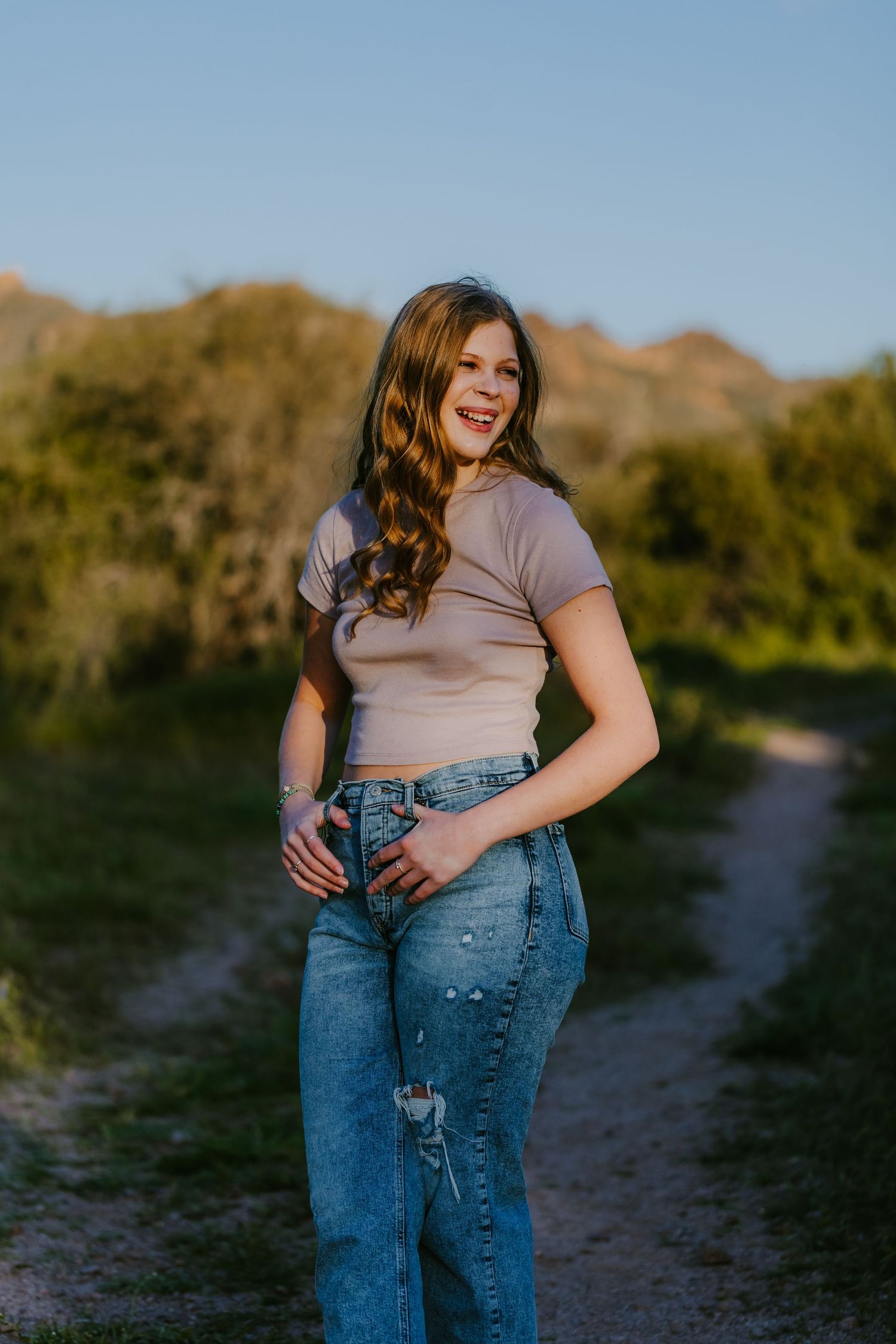 Casual lifestyle portraits on desert path with mountains and greenery.
