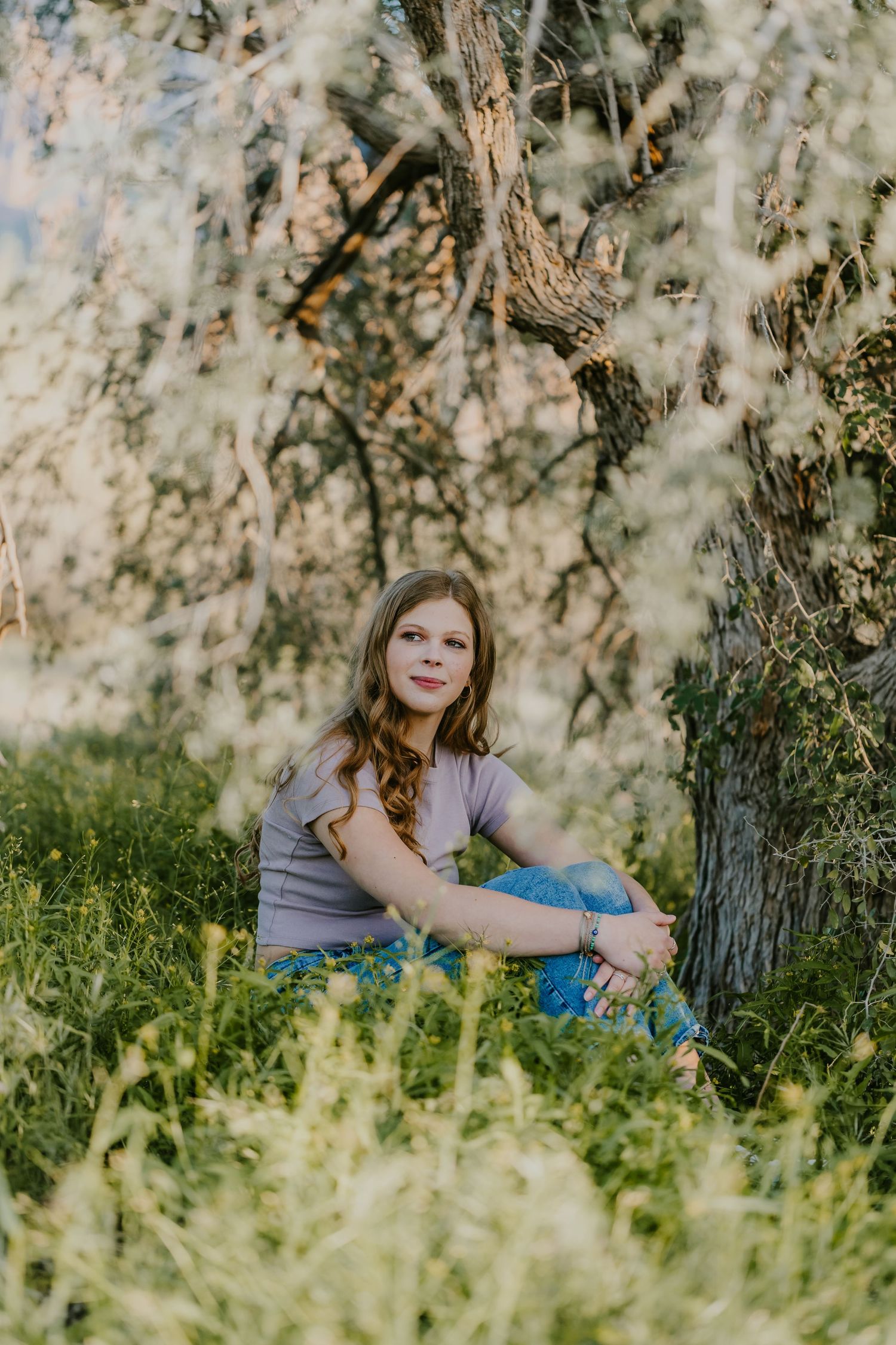 Outdoor portrait session in a grassy field with soft natural lighting and dreamy bokeh effect.