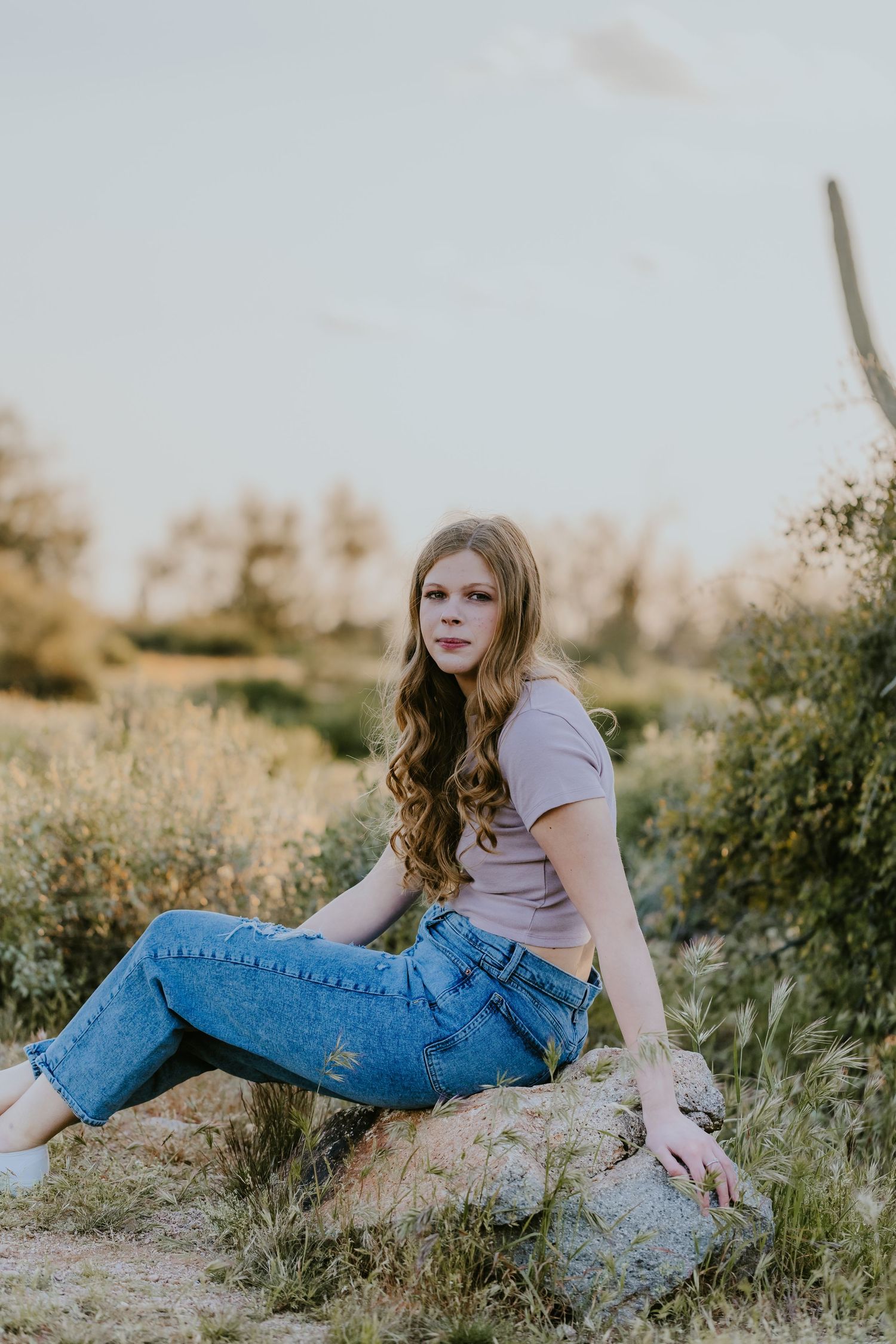 Relaxed outdoor portrait session featuring denim and casual attire in natural desert setting.