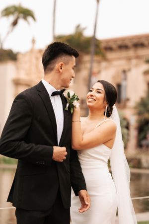 Happy couple embraces and laughs during outdoor wedding portraits.