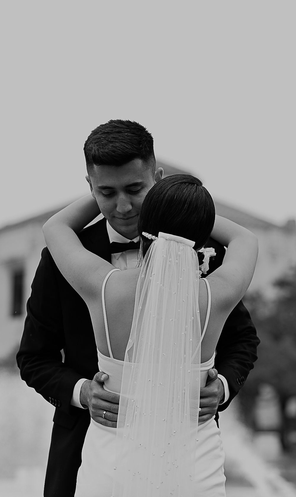 An intimate black and white wedding portrait showing a tender embrace.