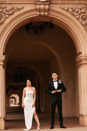Elegant wedding portraits taken under historic archways with warm lighting.