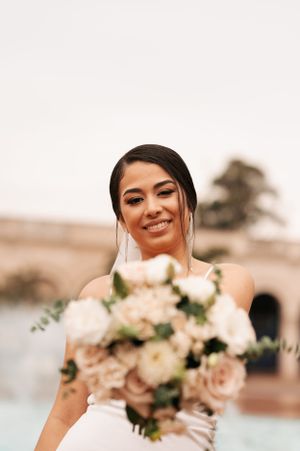 Elegant wedding photo showing beautiful bridal bouquet with blush roses and white flowers.