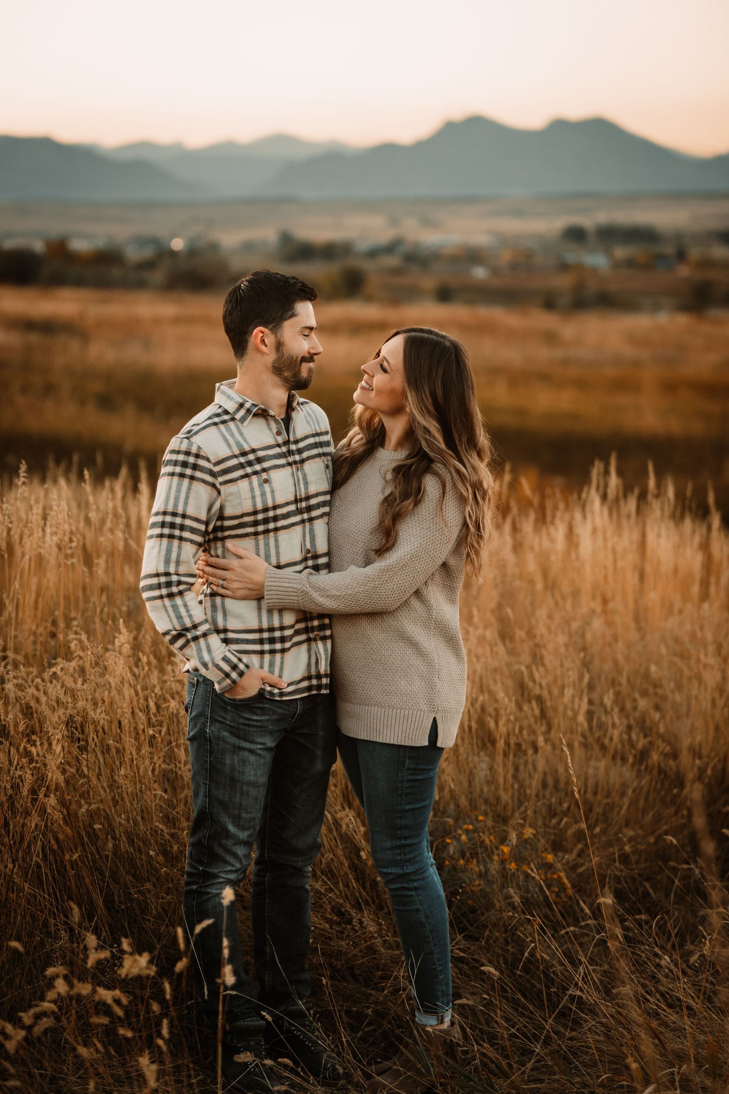 Couple embracing in field with mountain views by Vine Photography in Salem Ohio