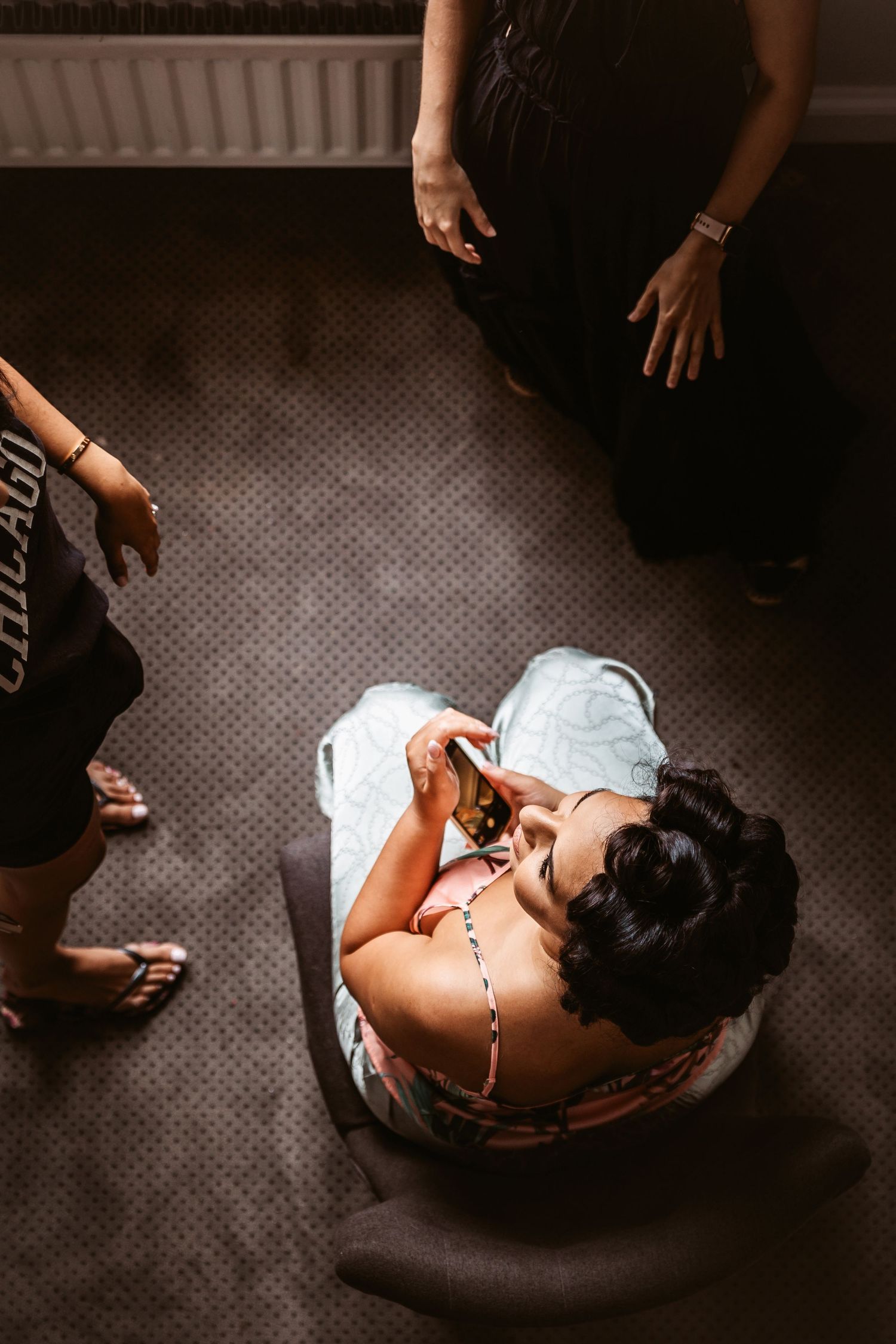 Overhead view of someone getting ready in a chair on dark carpeted floor.