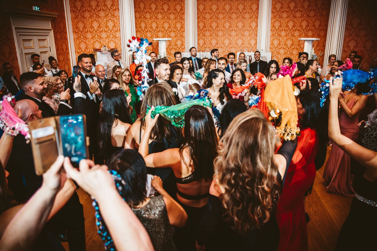 Lively wedding reception dance floor filled with celebrating guests and blue balloons.