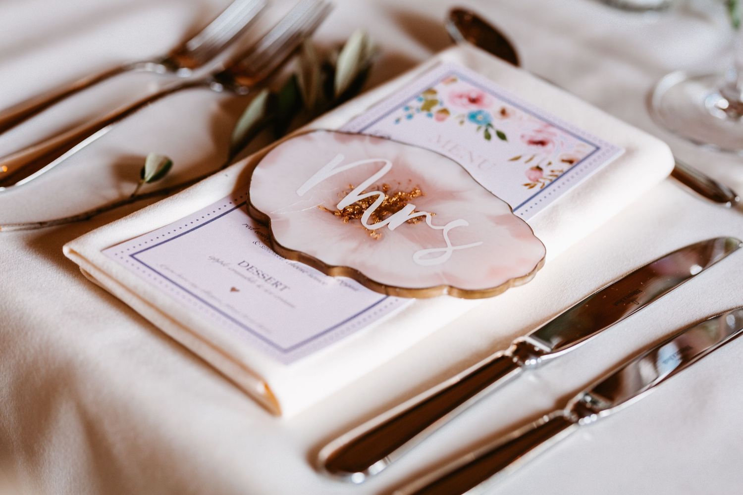 Detailed view of wedding menu and place card with delicate floral design.