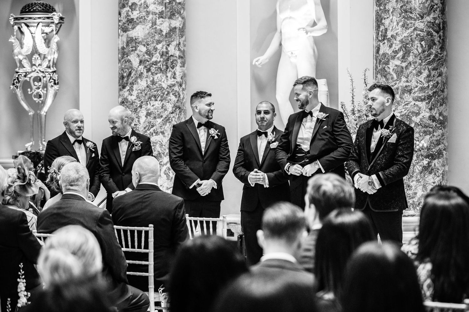 Black and white photo of wedding ceremony in progress with classical architectural details.