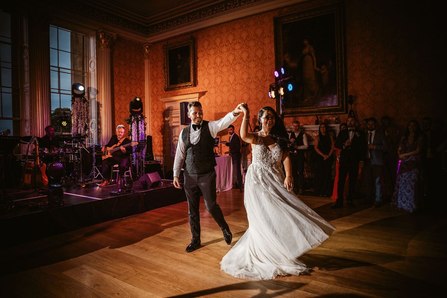 Wedding couple shares an intimate dance moment in a luxurious vintage ballroom.