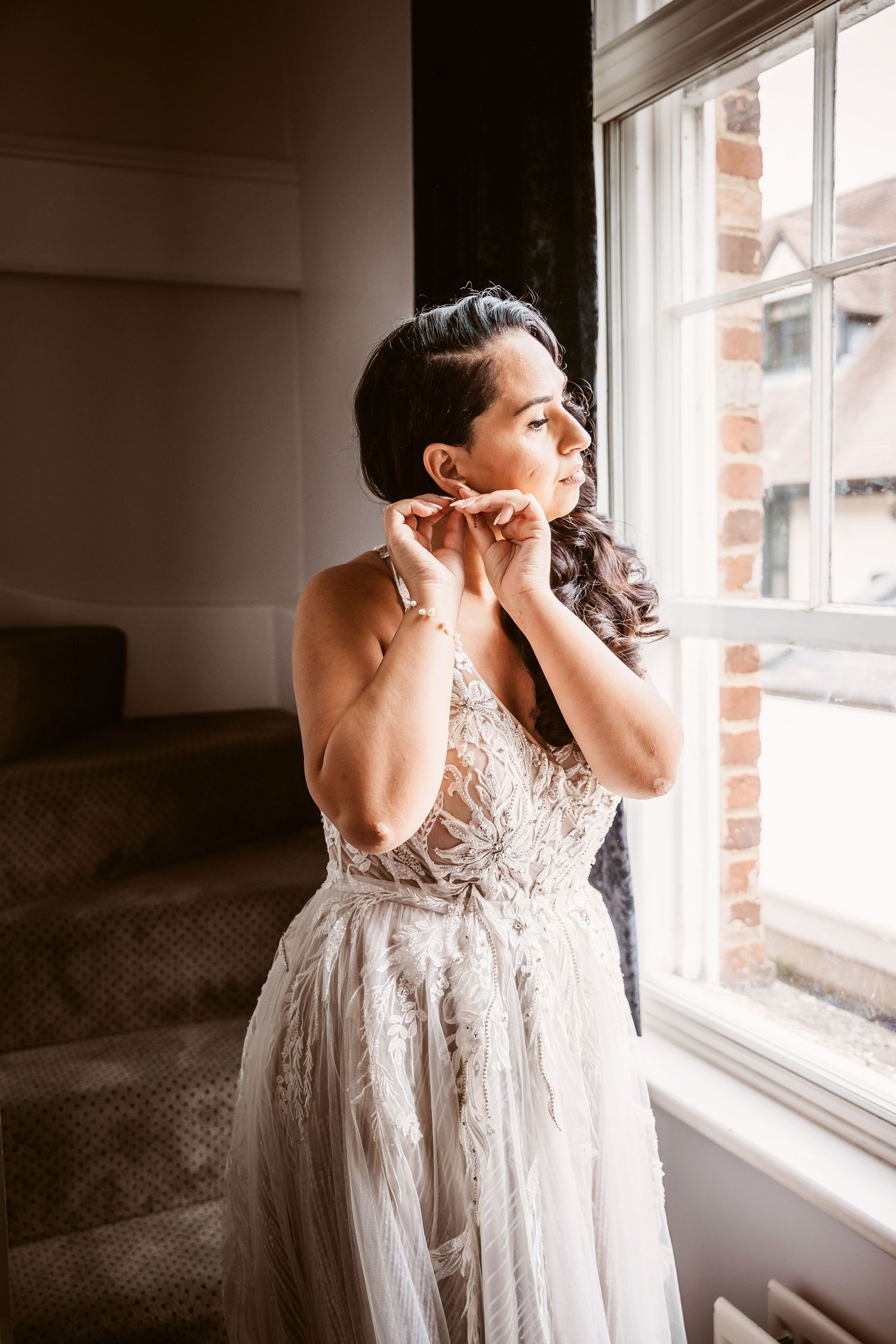Wedding preparation scene by a window with natural light streaming in.