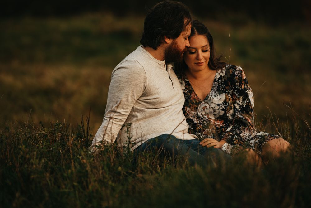 Romantic couple shares intimate moment on hillside at dusk.