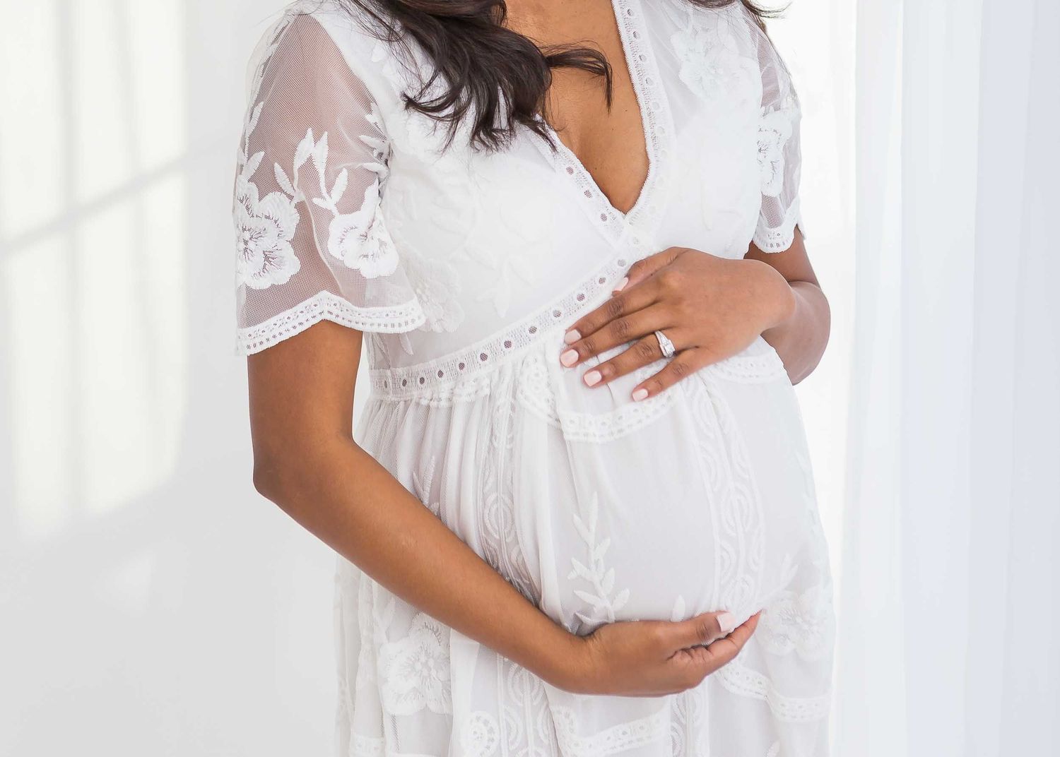 pregnant woman in white dress holding baby bump, maternity photos chattanooga, maternity photoshoot with family, studio