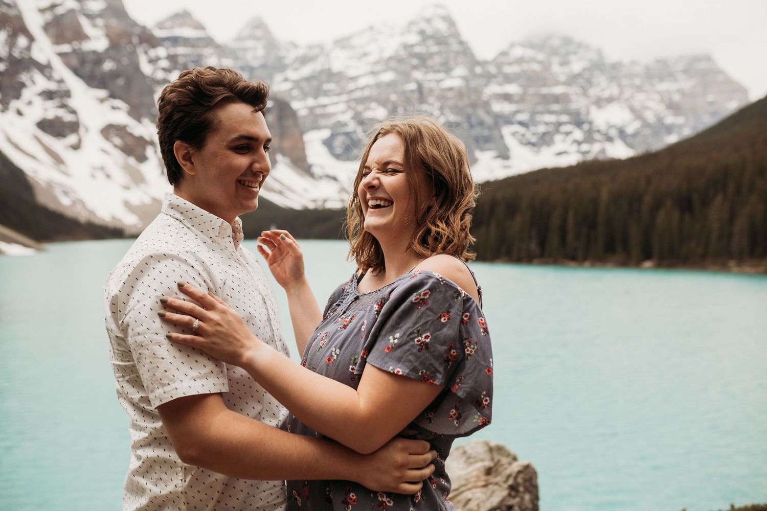 A joyful moment shared between a couple at scenic Moraine Lake in the Canadian Rockies.