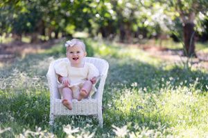 One Year Old Portraits in Walnut Orchard with white wicker chair in Orland, California