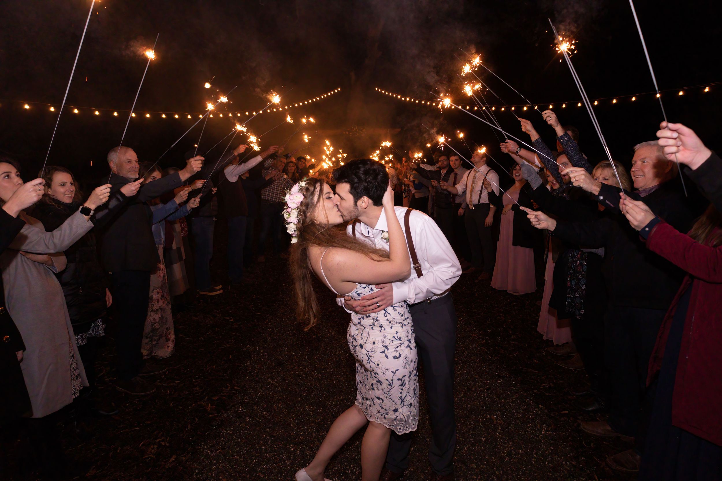 Bride and groom during sparkler exit with market lights above at Orland California Wedding