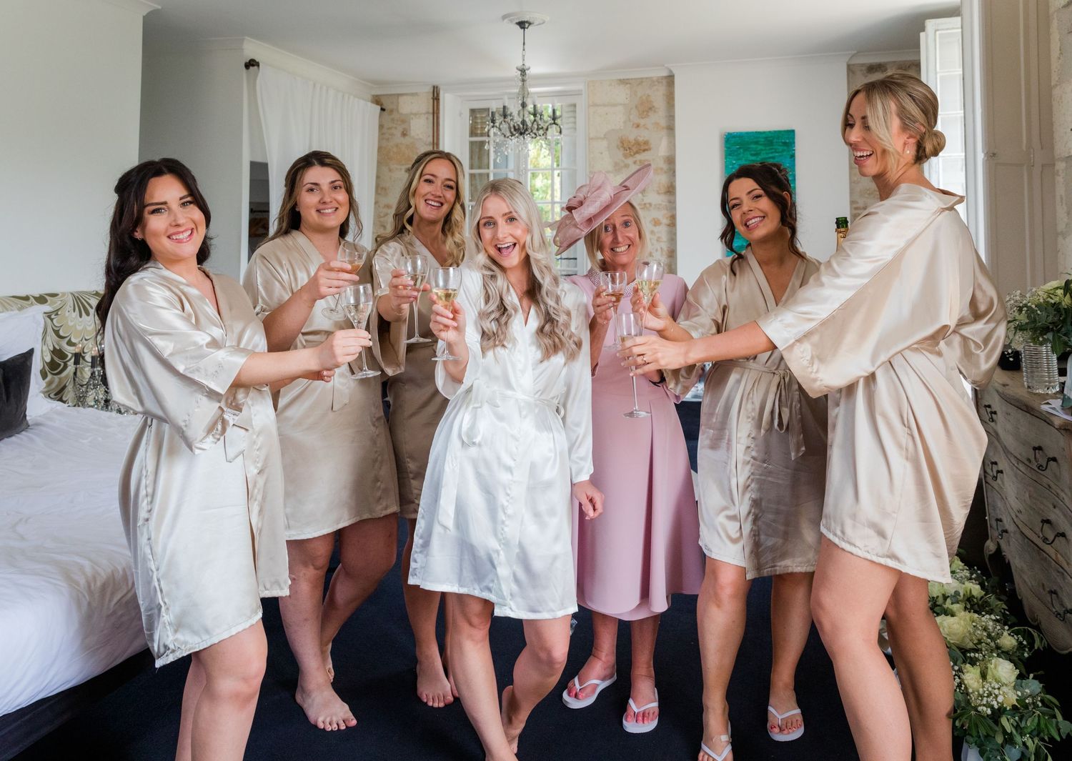 A celebratory toast with champagne glasses by a group wearing matching robes.