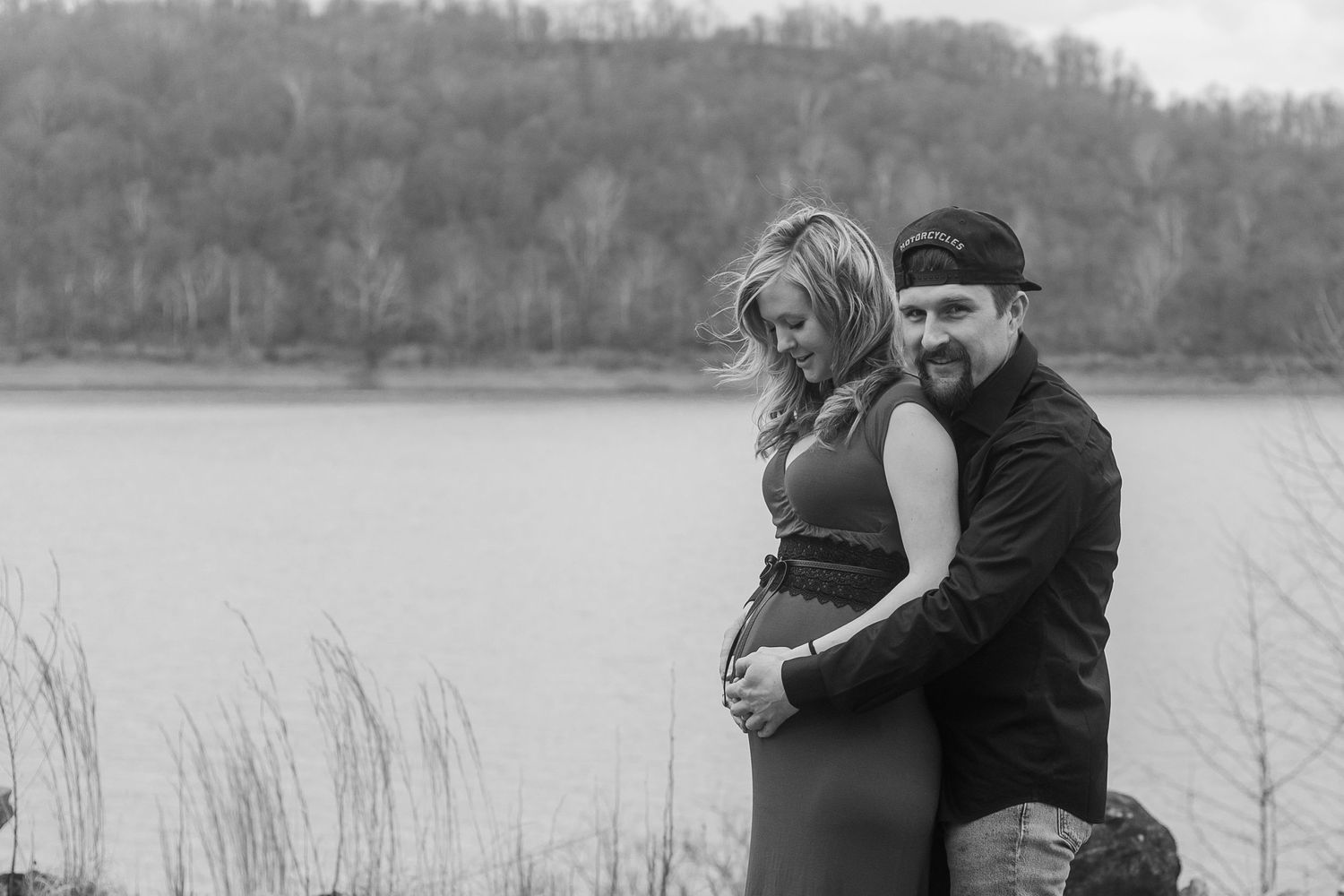A couple embraces during their winter lakeside photoshoot.