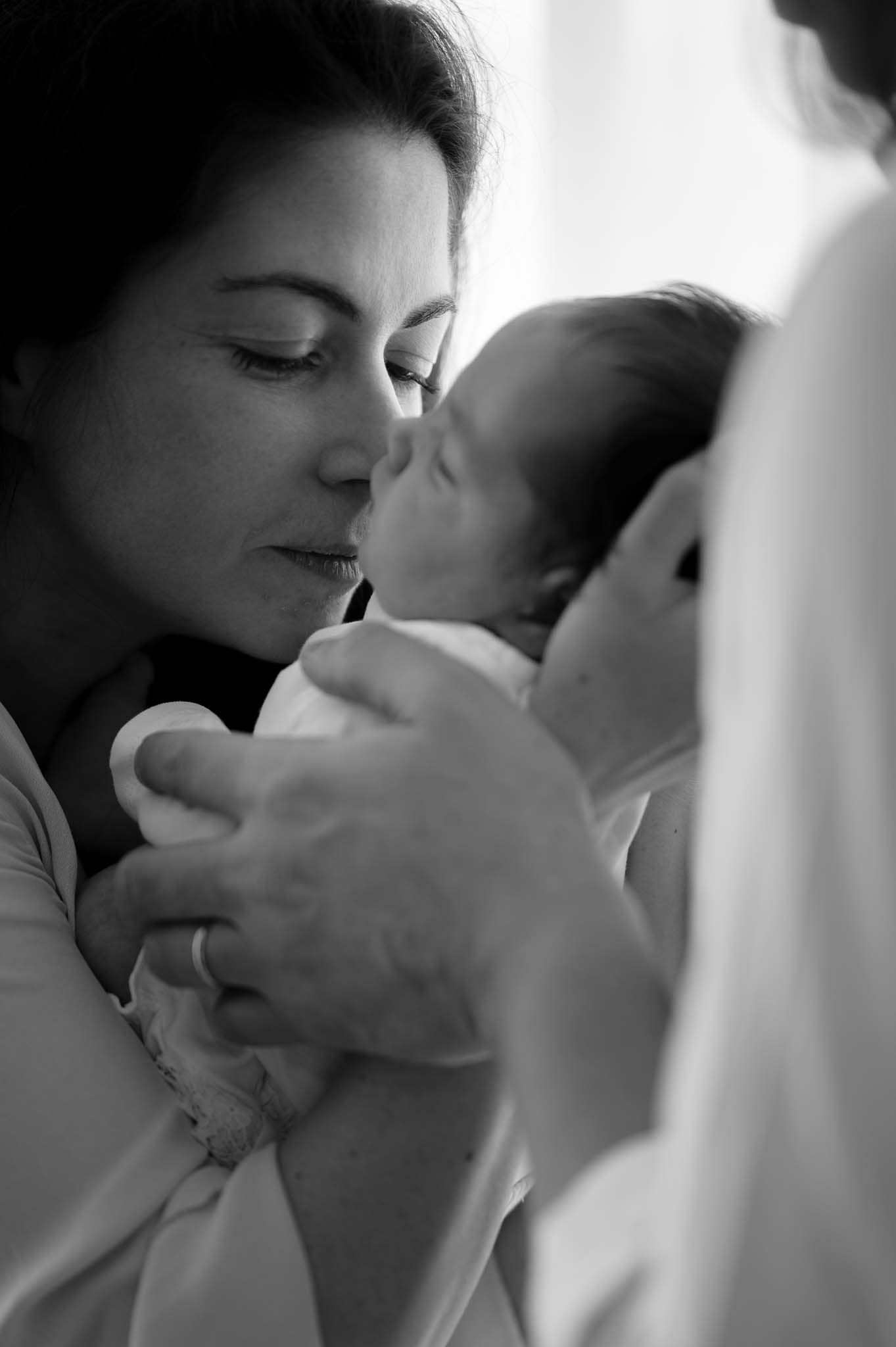 Intimate black and white portrait of tender moment with sleeping newborn.