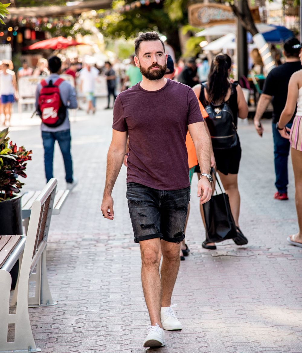 Ben walking by Quinta Avenida, with the crowd and streets of Playa del Carmen in the background