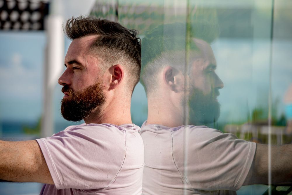 Ben sitting on his rooftop in Playa del Carmen showing his reflection on the wall in a creative way