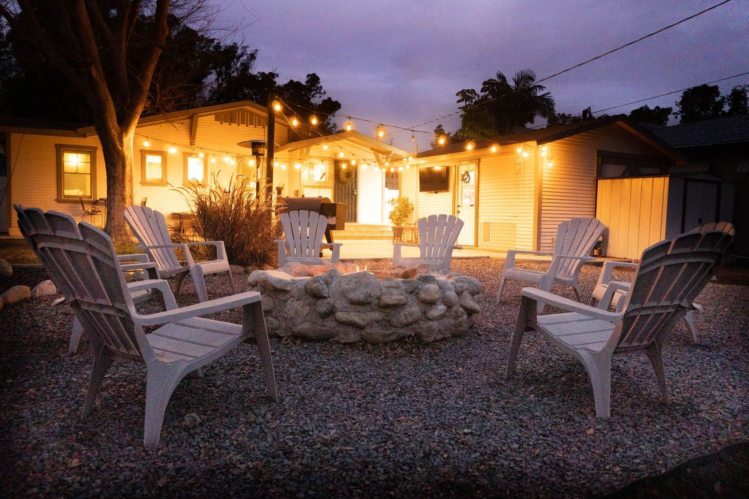 Evening patio scene with Adirondack chairs and warm exterior lighting creating a cozy atmosphere.