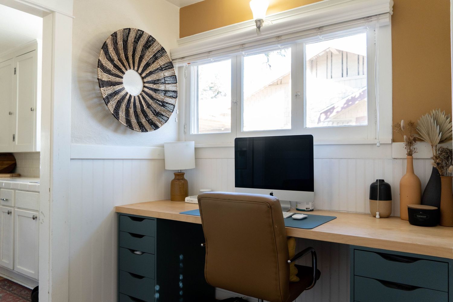 Contemporary home office space with wooden accents, TV mount, and modern circular wall decor.