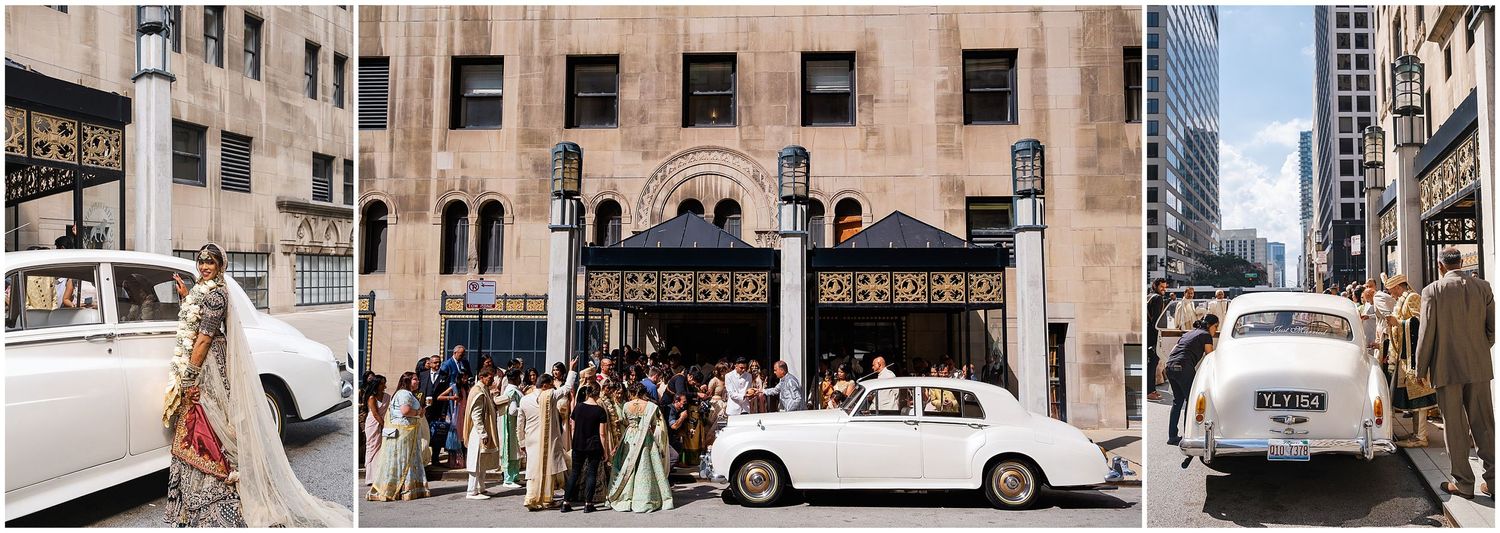 Vintage white car parked on city street with historic building facade in background.