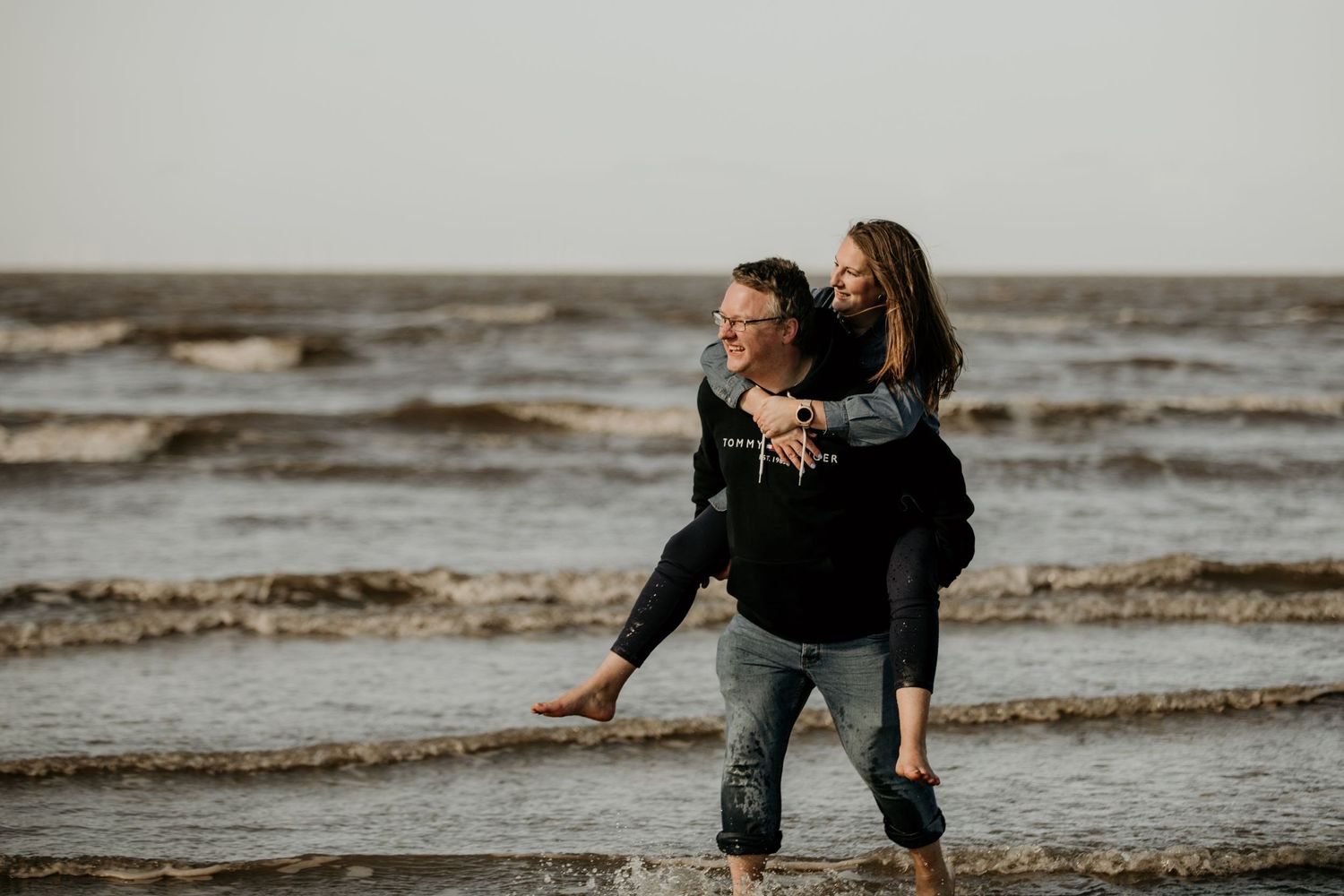 couple having a piggy back whilst in the sea