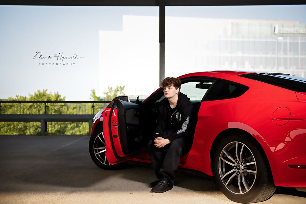 Stylish red sports car with open door in a modern parking structure.