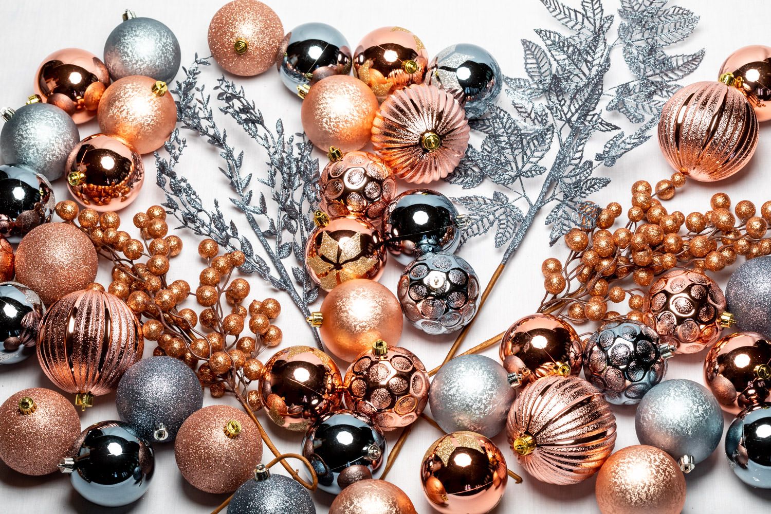 A product packshot of silver and rose gold Christmas decorations by Danny Loo